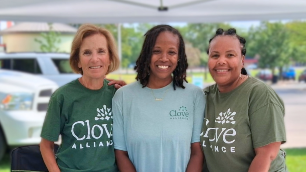 Three women pose together wearing Clove Alliance t-shirts